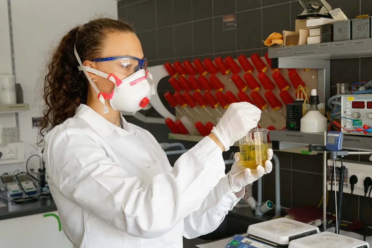 NanoKraft-Mitarbeiterin prüft frisch hergestelltes kolloidales Silber im Becherglas – eigenes Labor in Braunau am Inn